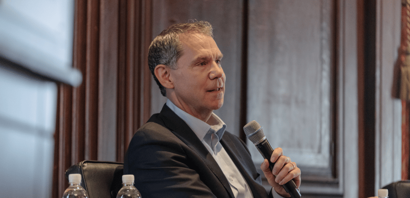 Justin Bekelman, MD, co-founder and CEO of Daymark Health, Philadelphia, speaks into a microphone while seated at a table.