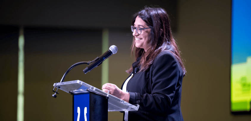 Gloria Sachdev, PharmD, secretary of health and family services for the state of Indiana, smiles while speaking at a podium.