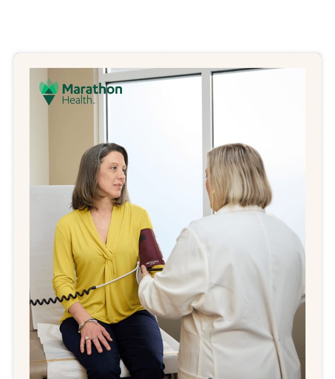 Smarter primary care, lower specialty spend: Marathon Health provider supports care coordination and care navigation through a patient blood pressure check in an exam room