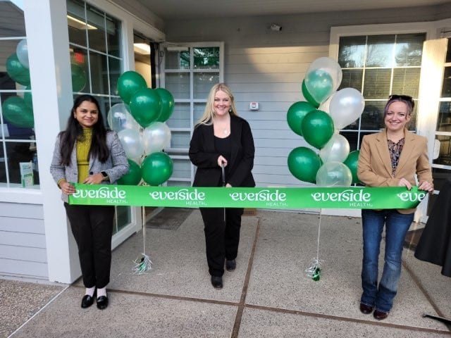 green ribbon cutting in front of everside health center