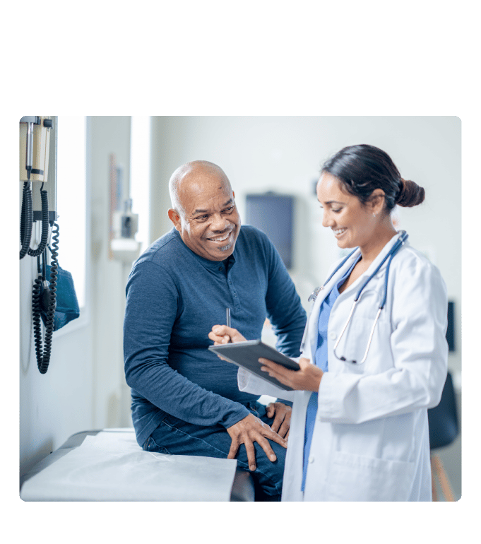 Physician reviewing a tablet with a smiling patient during an advanced primary care visit.