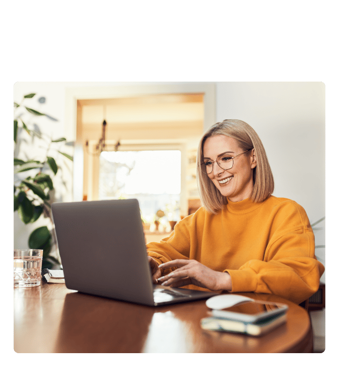 Woman wearing glasses and an orange sweater smiling while interviewing during a video call.