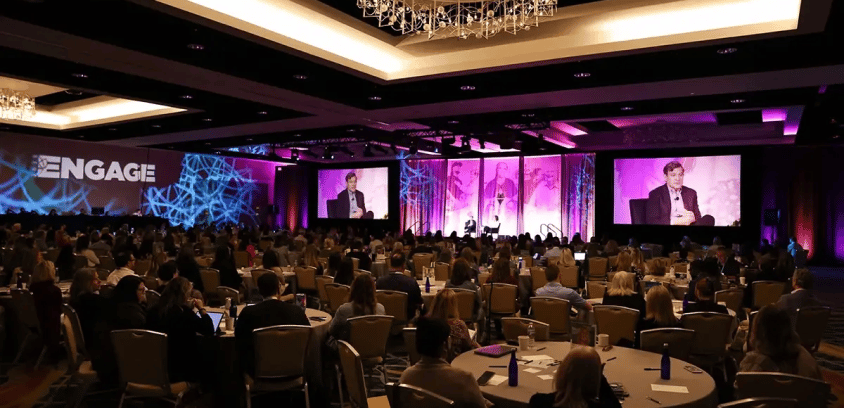 Dan Harris giving a talk on stage at ENGAGE 2025 conference.