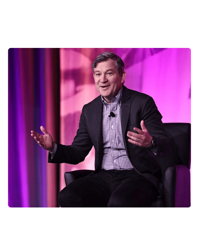 Dan Harris gesturing onstage during a keynote presentation on mindfulness.