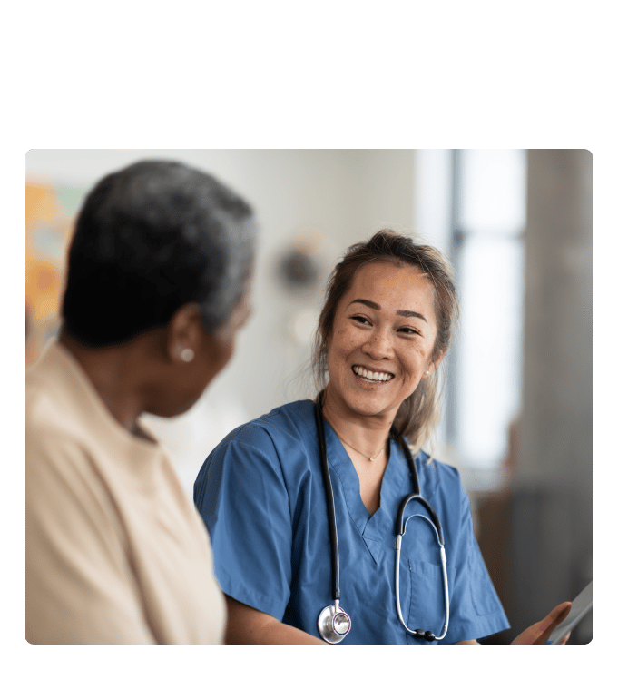 Healthcare provider smiling during a conversation with a person in a clinic setting.