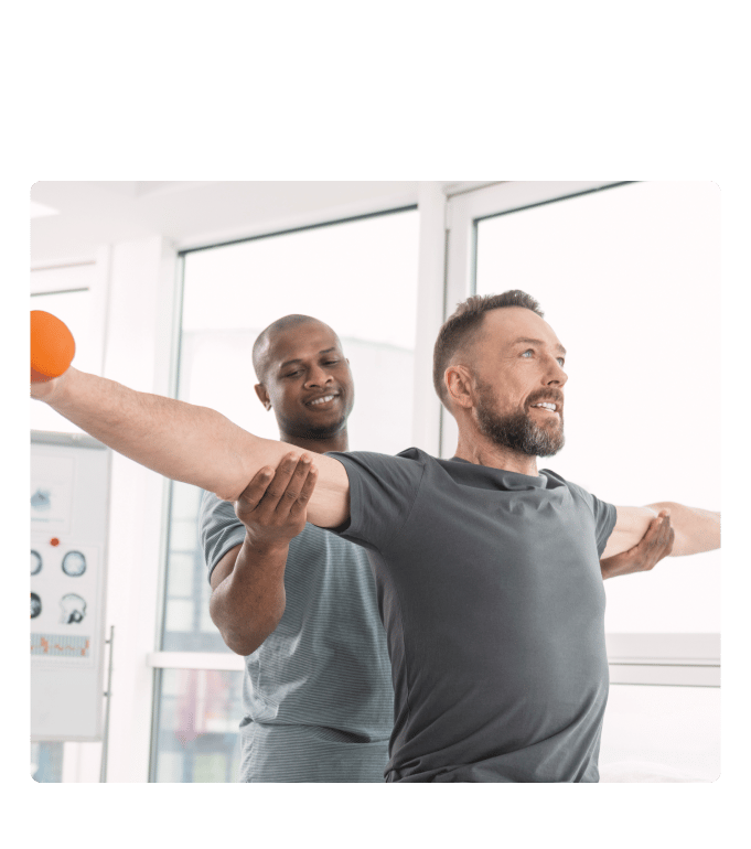 Healthcare professional guiding a person through an arm-extension movement at an occupational health session indoors