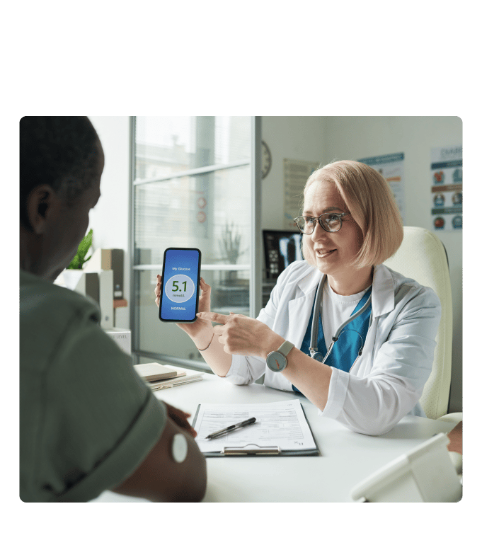 Healthcare provider in a white coat showing a glucose reading on a smartphone to a person with diabetes.