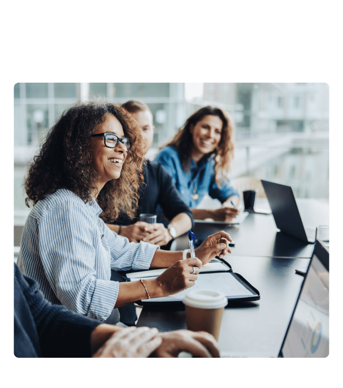 Smiling employees answering population health questions in a conference room.