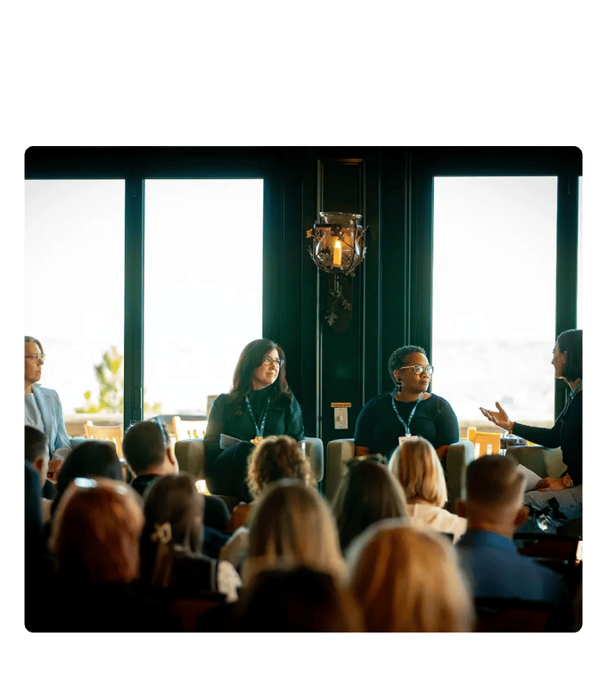 Three panelists seated at the front of a conference room address an audience during Engage 2026.