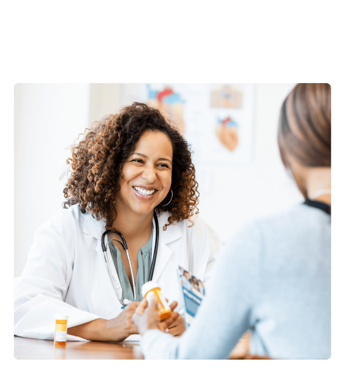 Healthcare provider discussing a prescription bottle with a person at an employer pharmacy.