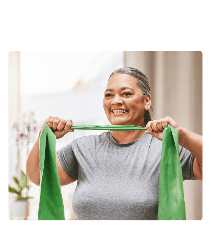 Employee smiling while stretching a green resistance band during a workplace weight loss challenge.