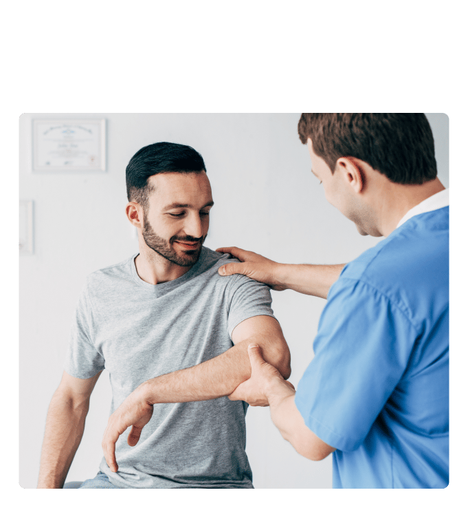 Physical therapist Will Fogarty assessing a person's arm and shoulder in a clinical setting.