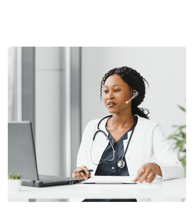 Virtual healthcare provider in a white coat and stethoscope speaking via headset during a virtual care visit.