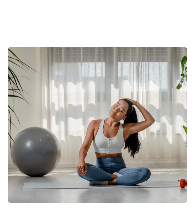 Person seated on a yoga mat stretching during a workplace wellness program.
