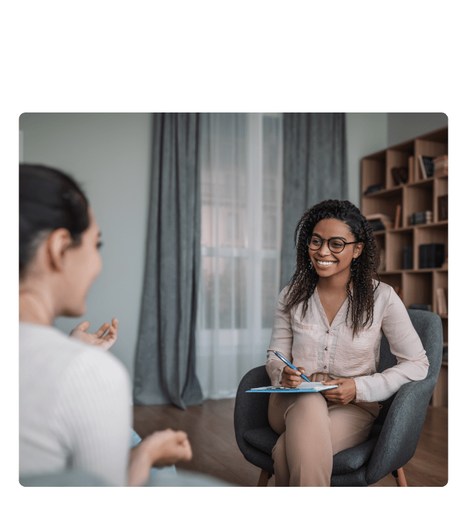 HR team member having a conversation with an employee in a warmly furnished office.