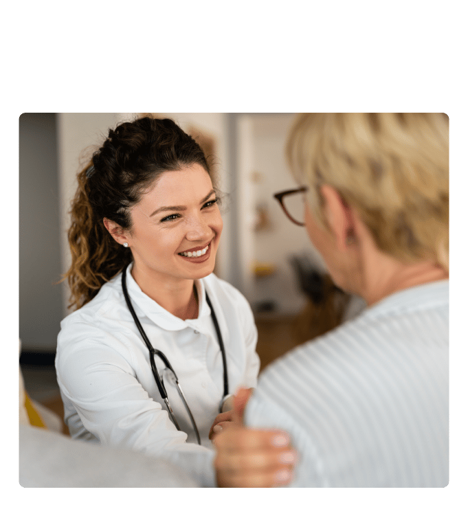 Healthcare provider smiling during a conversation with a person at a primary care clinic.
