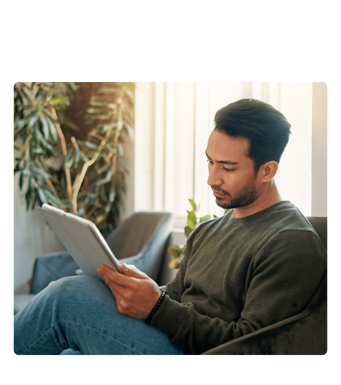 Employee filling out a health risk assessment on a tablet while seated on a sofa.