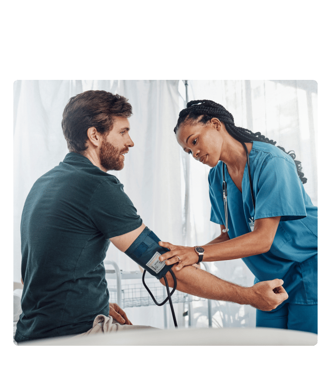 Medical assistant in scrubs taking a person's blood pressure.