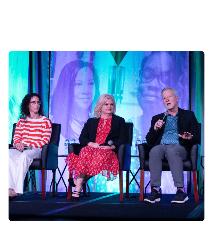 Three panelists seated on stage with microphones at the ENGAGE 2025 conference during a main-stage panel discussion.