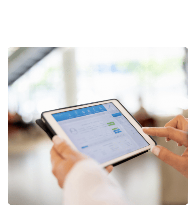 Person reviewing a healthcare data dashboard on a tablet in a bright office setting.