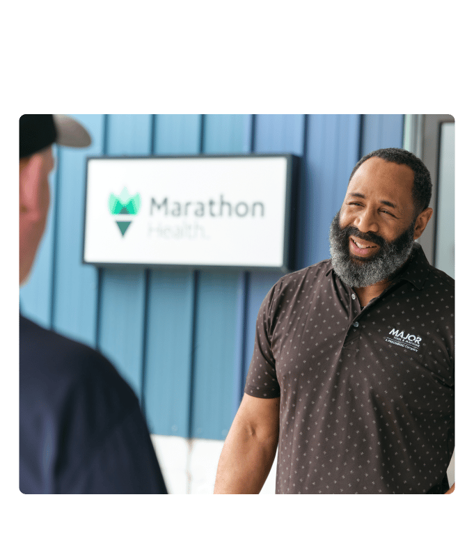 Employee laughing with a coworker outside a Marathon Health worksite clinic.