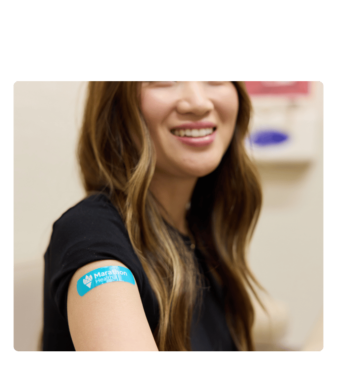 Smiling patient with Marathon Health bandage after a same-day appointment.