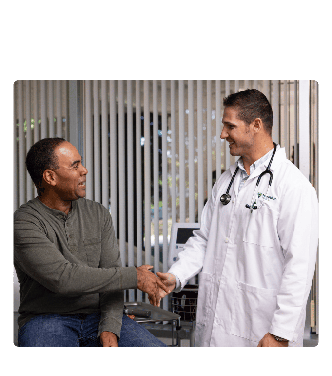 Healthcare provider in a white coat shaking hands with a Tyson Foods employee at a clinic.
