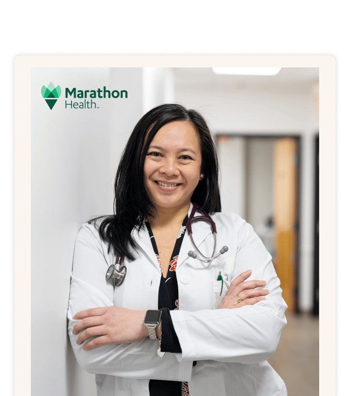 Marathon Health physician standing confidently in an onsite employee health center hallway.