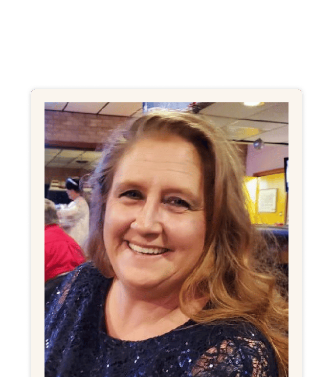 Rhonda Dunn smiling in a navy sequined top at an indoor social gathering