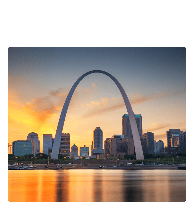 St. Louis skyline at sunset with the Gateway Arch framing the Old Courthouse above the Mississippi River.