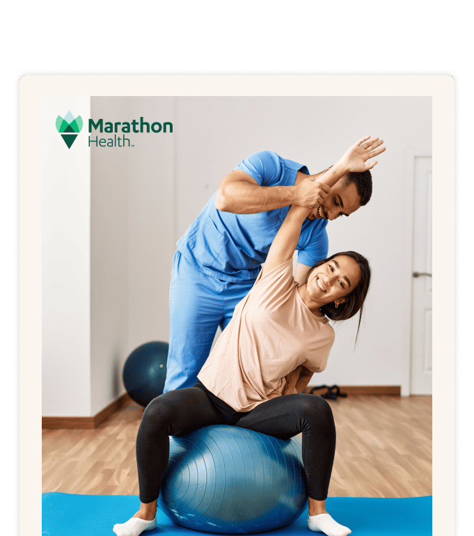 A provider in scrubs guides a person stretching on an exercise ball