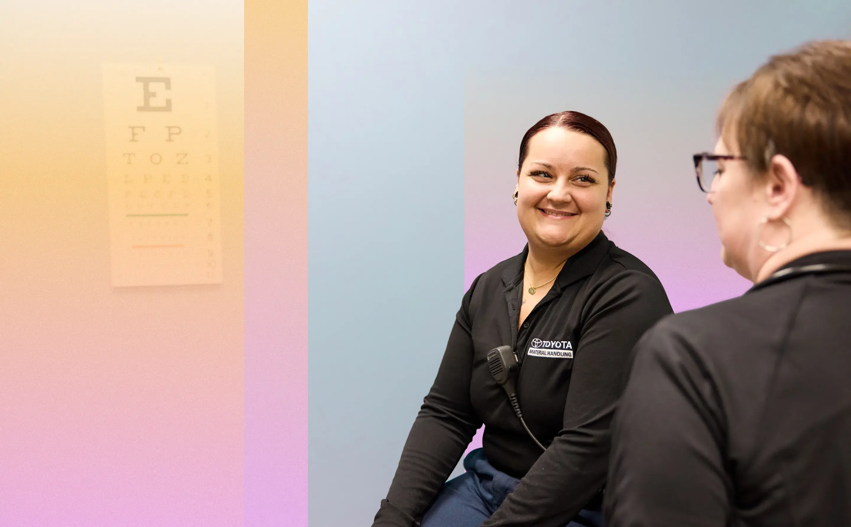 Two smiling Toyota employees engaged in conversation.