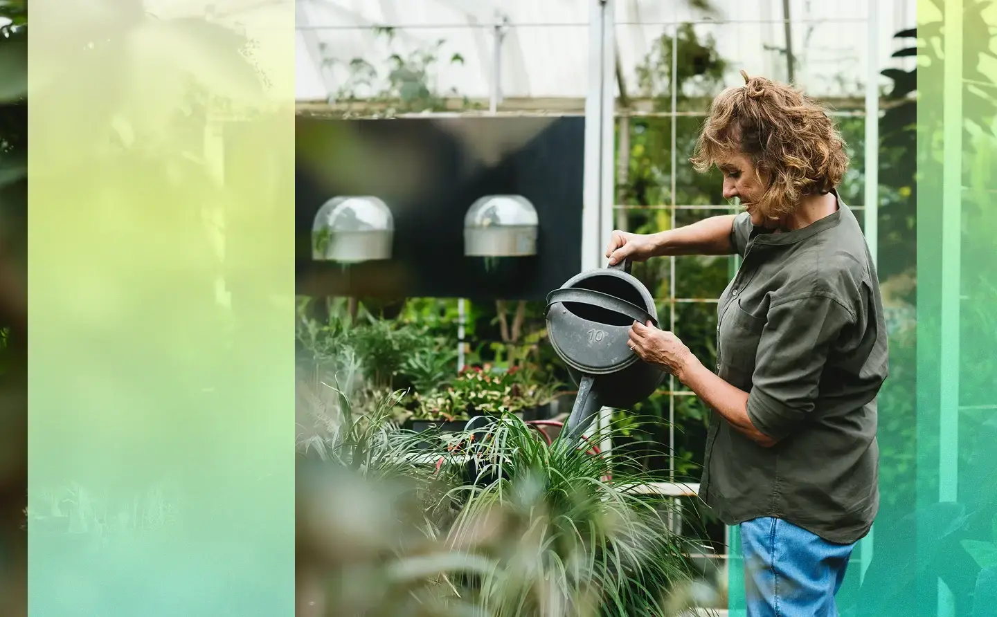 Woman watering plants in her greenhouse.
