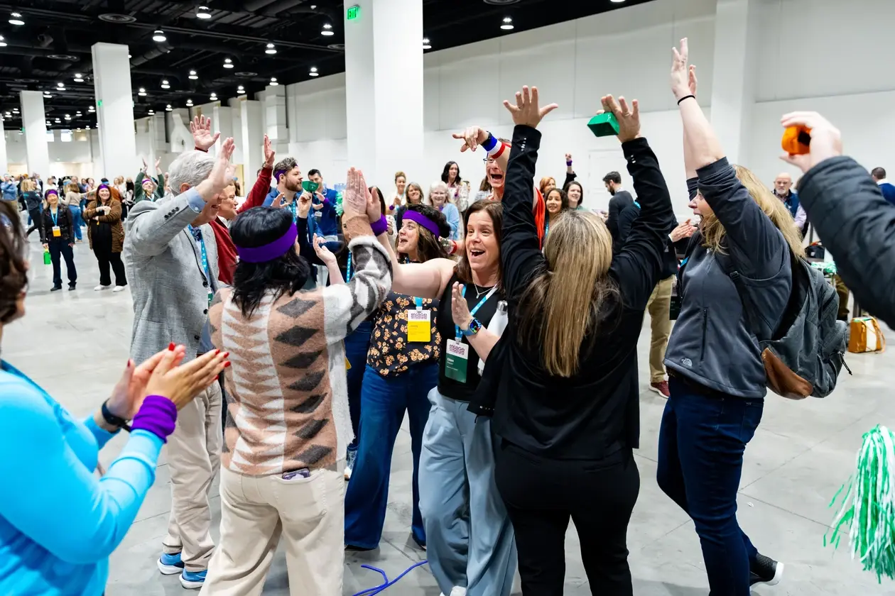Attendees raising their hands during a group activity