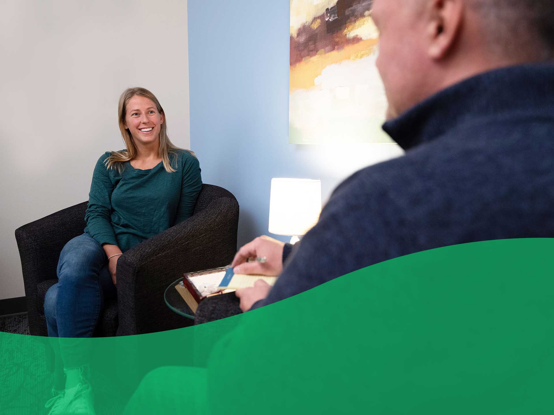 patient sitting in chair talking to doctor