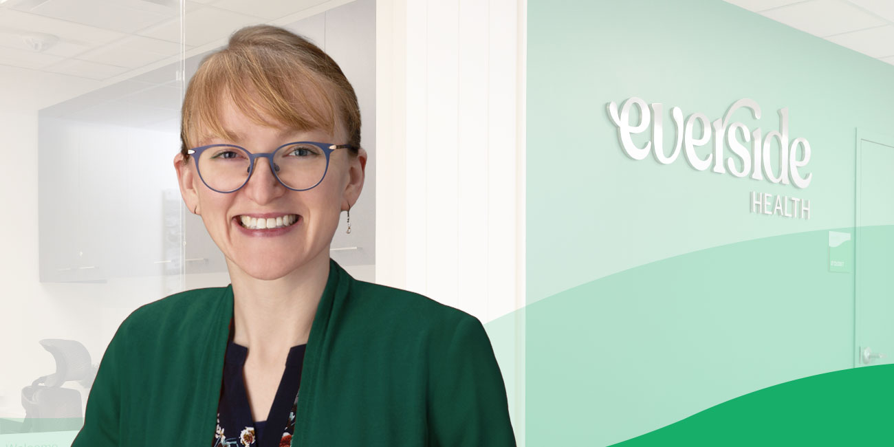 woman smiling in front of everside health logo