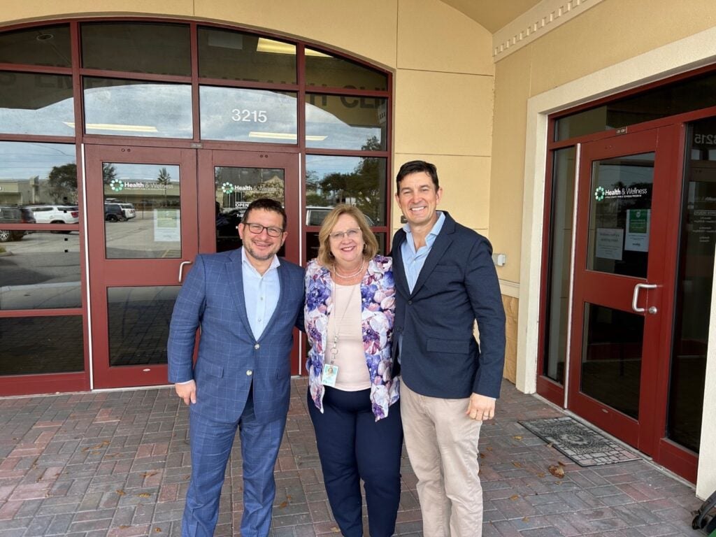 Mike Michetti, Linda King, and Chris Miller in front of building