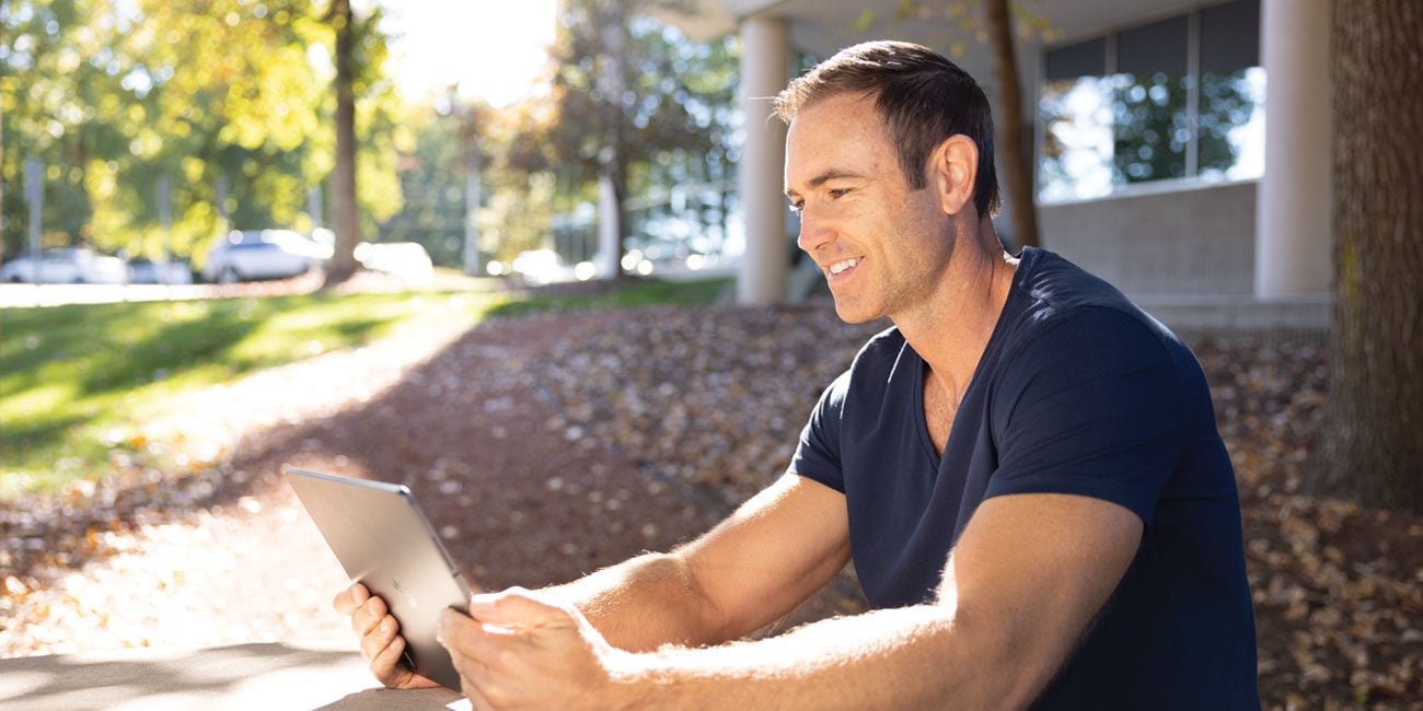 Man outside looking at an electronic device