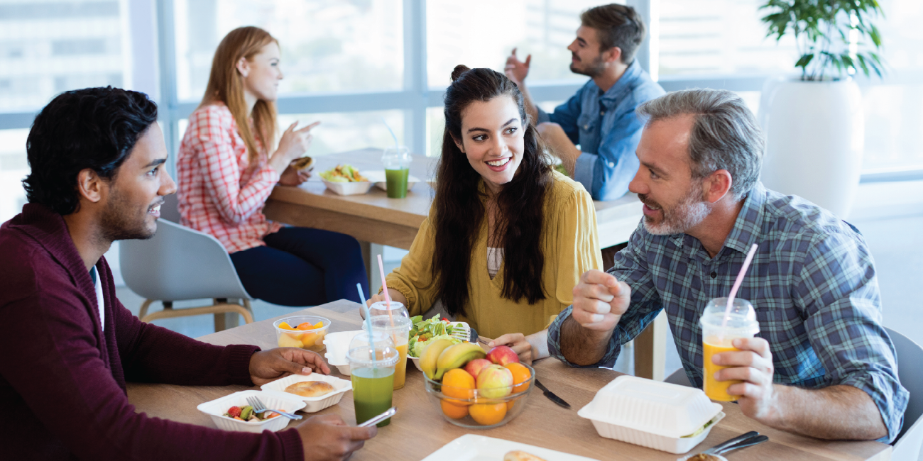 Happy, engaged workers sharing lunch in the office