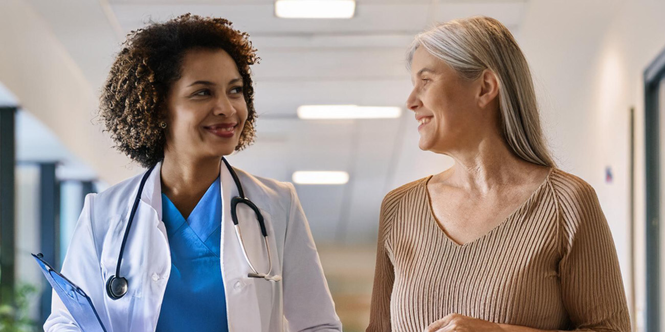 A middle-aged woman speaking with a female physician