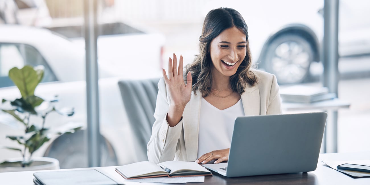 A woman smiling at her laptop during a video interview