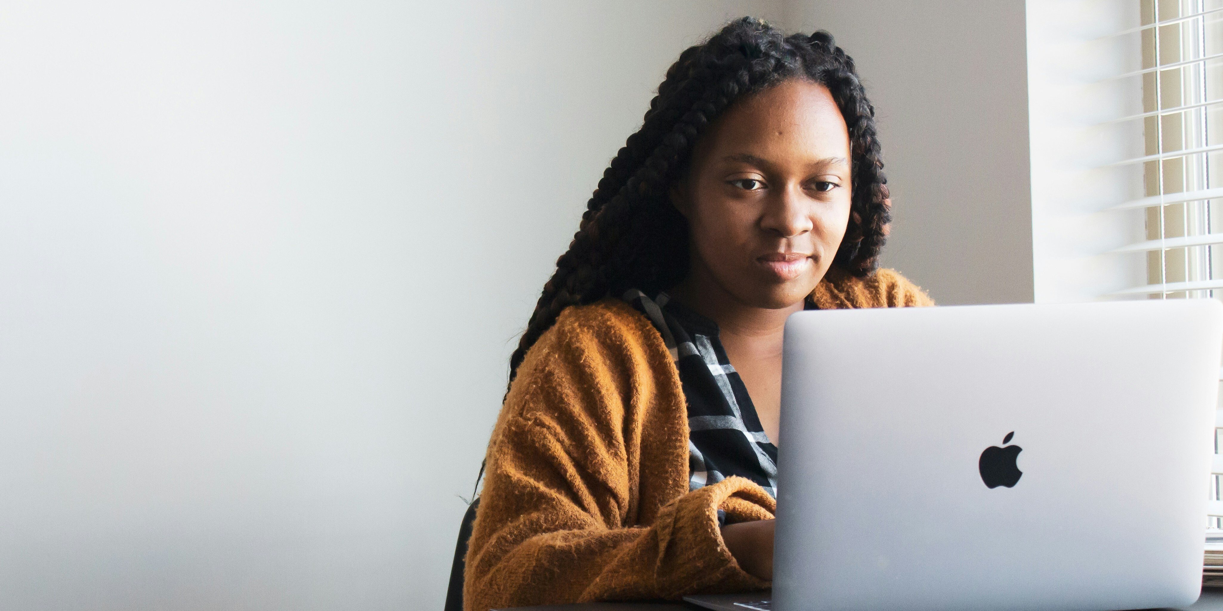 A women at her laptop on a virtual primary care appointment
