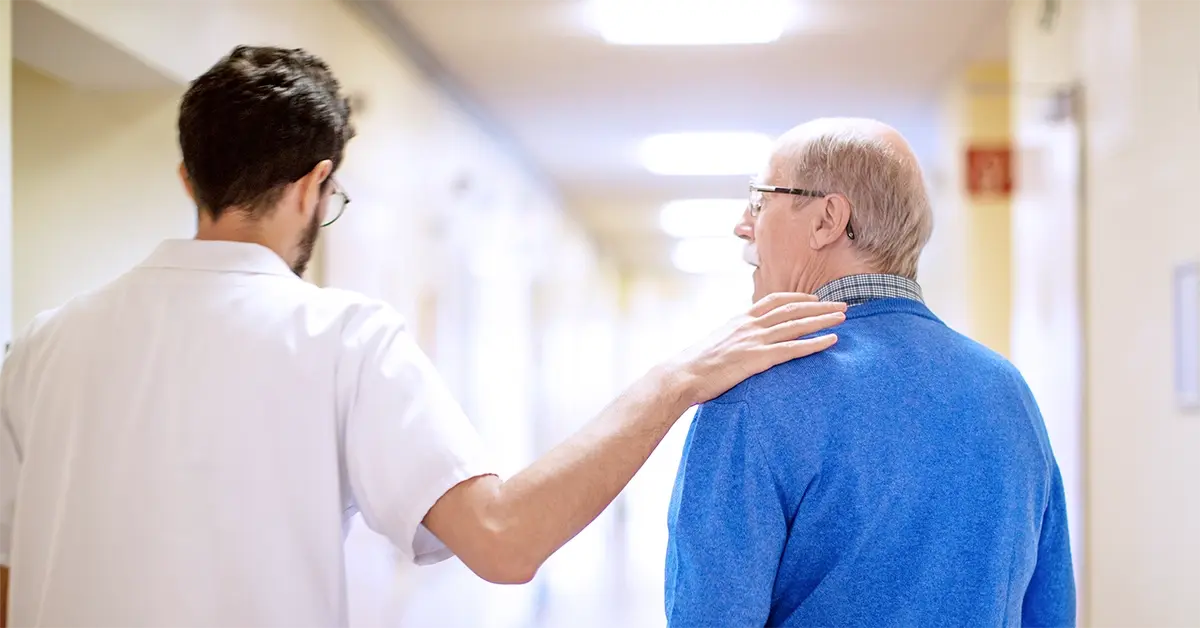 Physician with his arm on a patient's shoulder.