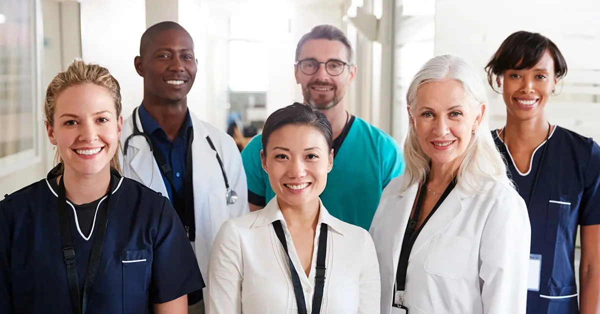 A group of smiling doctors and physicians posing for a photo.