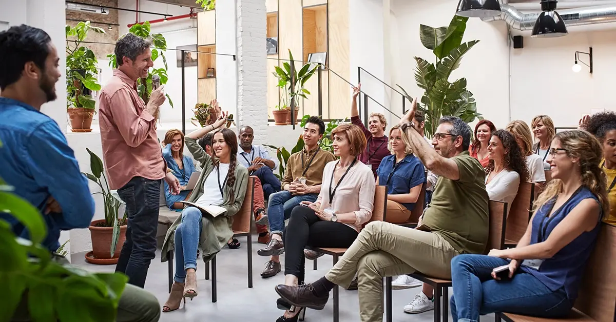 Employer conducting employee communications in a crowded room.