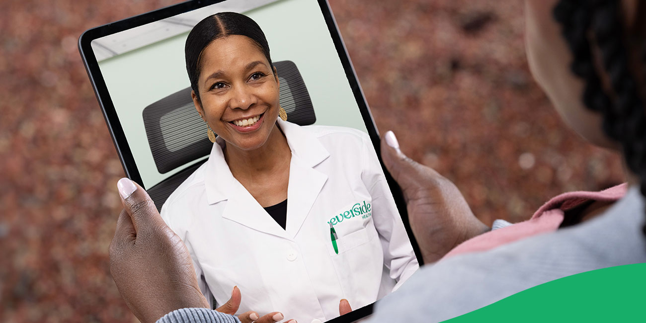 physician smiling on a tablet screen in hands