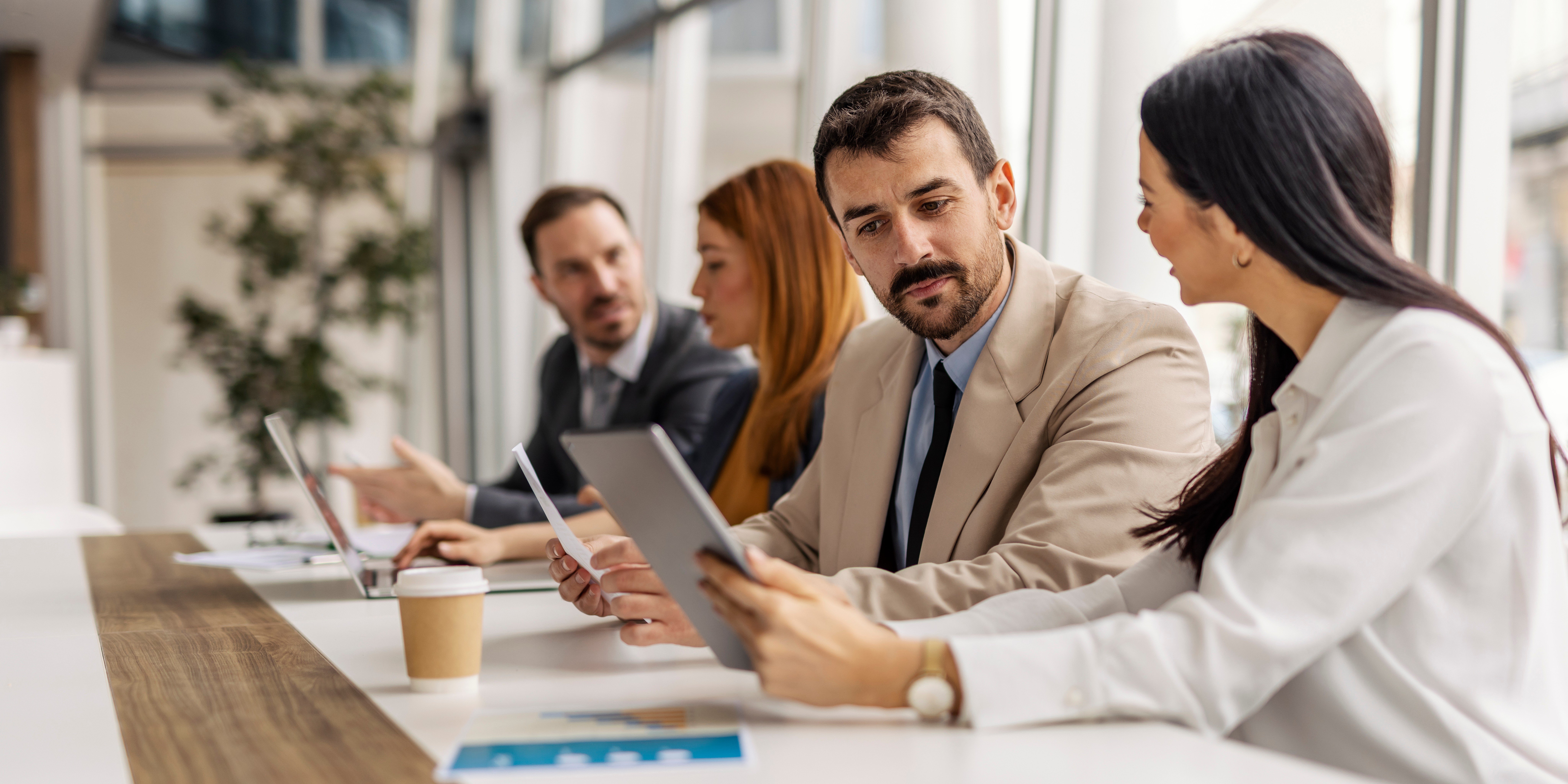 Executives reviewing documents on a tablet