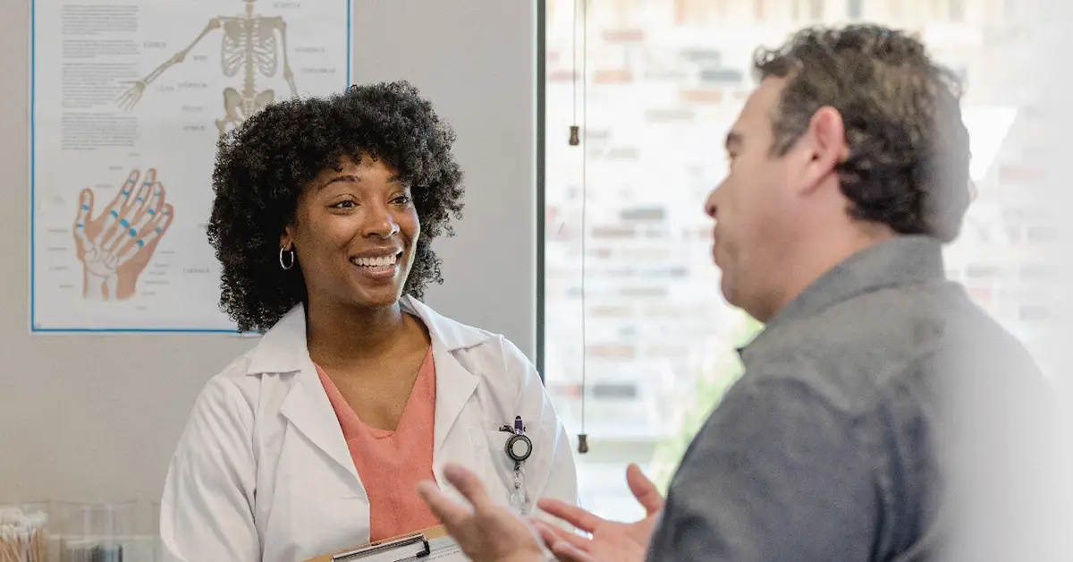A provider smiling while a patient discusses fiscal responasability.
