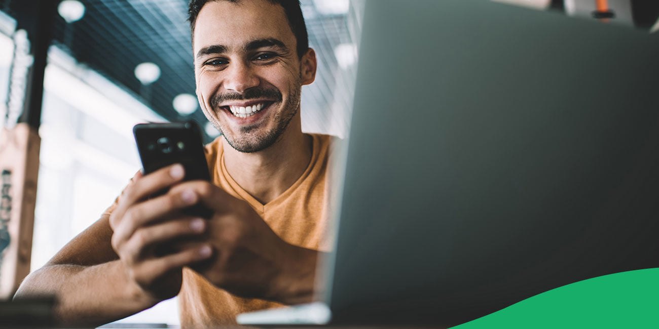 man smiling looking at mobile device