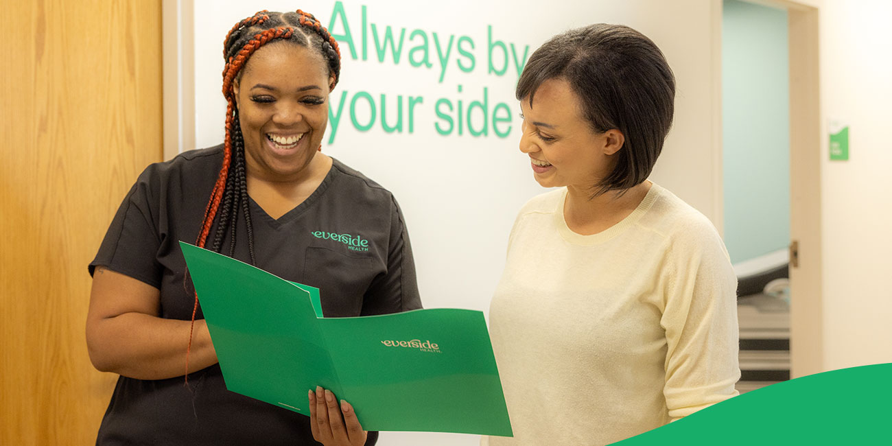 nurse showing patient documents inside a folder